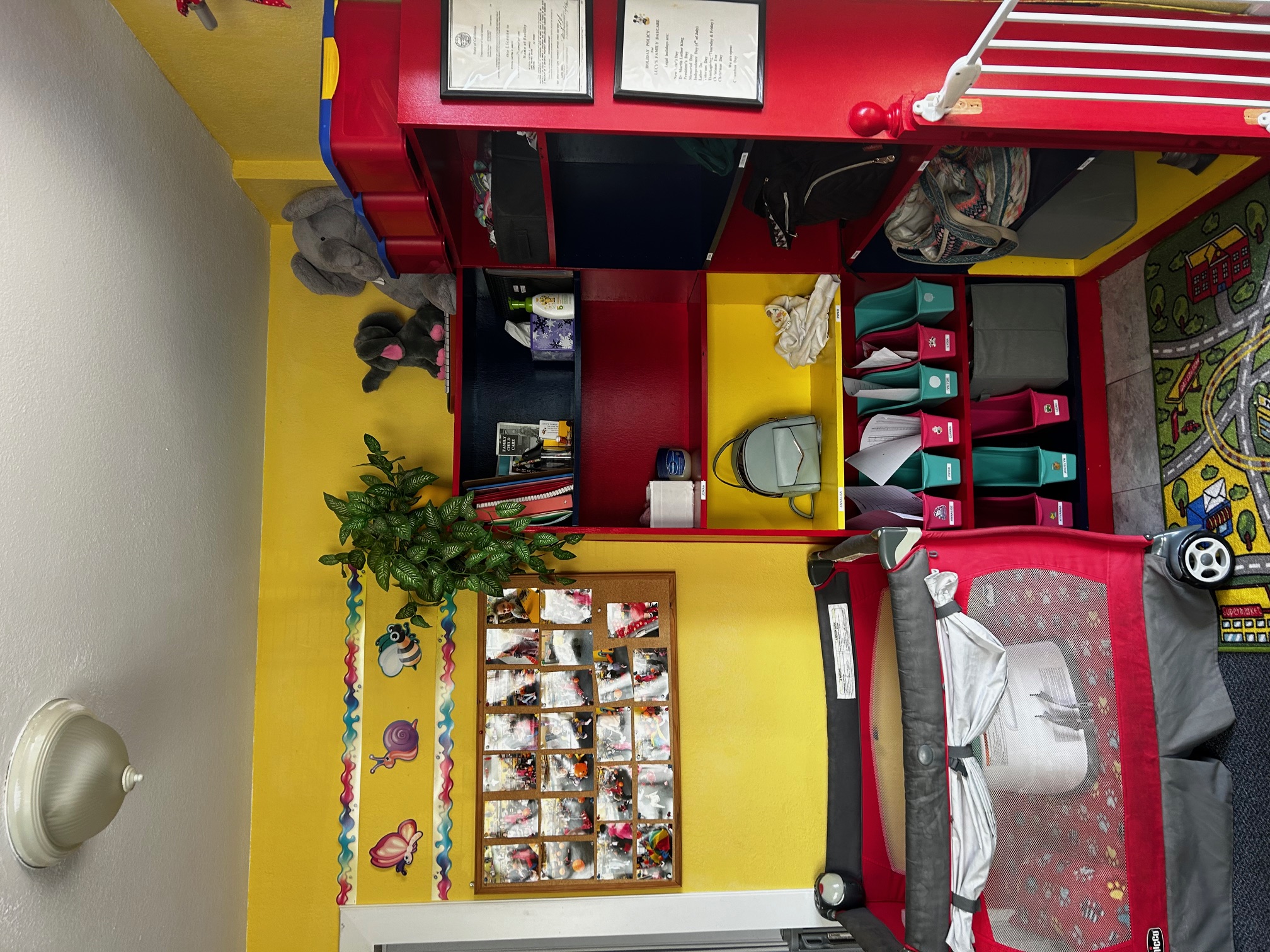 A corner of the daycare, with a baby carriage and some filled cubbies.